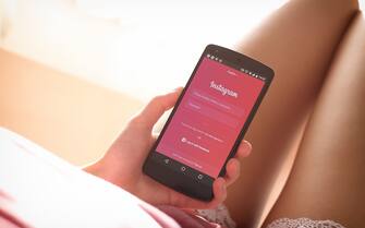 A woman enters Instagram via her smartphone