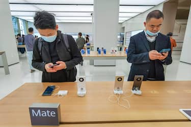 People wearing masks try out the newly launched Huawei Mate40 mobile phone at the Huaweis flagship store in Shanghai on October 23, 2020. (Photo by STR / AFP) (Photo by STR/AFP via Getty Images)