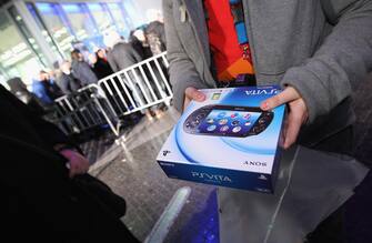 139454091 BERLIN, GERMANY - FEBRUARY 21: A young man shows off his new Sony PlayStation Vita portable gaming device that he just bought at the Sony Store during the official German launch of the new Vita on February 21, 2012 in Berlin, Germany. Several hundred video gaming enthusiasts waited hours in line to be among the first to buy the new device. (Photo by Sean Gallup/Getty Images)