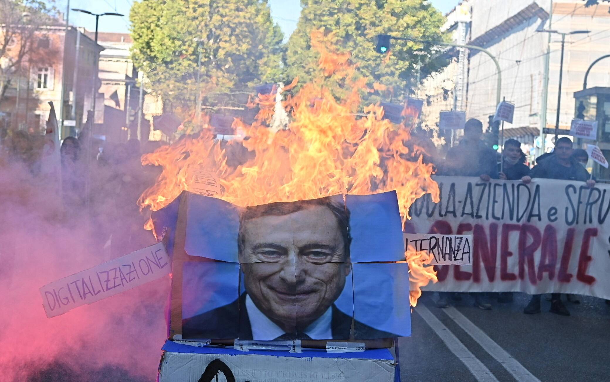 Una gigantografia di Mario Draghi data alle fiamme dagli studenti che stanno manifestando in corteo a Torino, 11 Ottobre 2021. Davanti alla sede del Miur, in corso Vittorio Emanuele, è stata bruciata anche una bandiera dell'Europa, Torino, 11 ottobre 2021 ANSA/ALESSANDRO DI MARCO