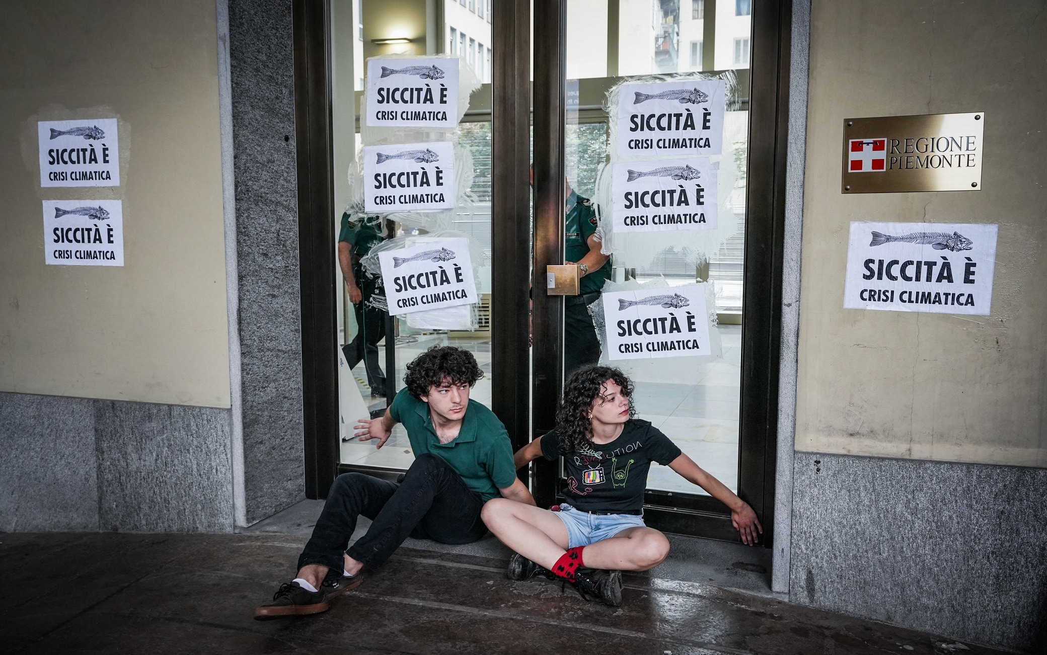 Alcuni attivisti di Extinction Rebellion si incollano letteralmente con il super attack, all'ingresso del palazzo della Regione Piemonte in Piazza Castello, per protestare contro il cambiamento climatico, Torino, 28 giugno 2022 ANSA/TINO ROMANO