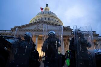 epa08923720 Police stand outside the East Front of the US Capitol at dusk as a curfew begins after pro-Trump protesters stormed the grounds leading to chaos, in Washington, DC, USA, 06 January 2021. Various groups of Trump supporters have broken into the US Capitol and rioted as Congress prepares to meet and certify the results of the 2020 US Presidential election.  EPA/MICHAEL REYNOLDS