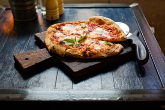 Pizza Margherita freshly baked on a table in cafe