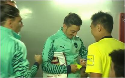 Özil firma l'autografo al cartellino dell'arbitro