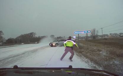 Un poliziotto evita un'auto su una strada ghiacciata. Video